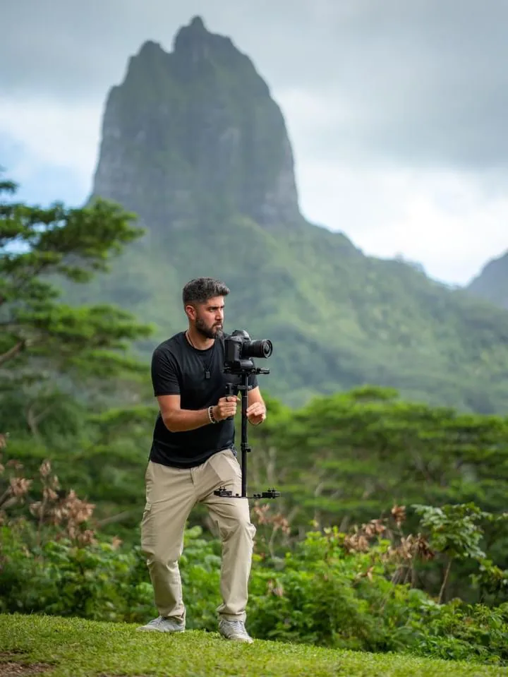 Filmmaker with camera in tropical landscape