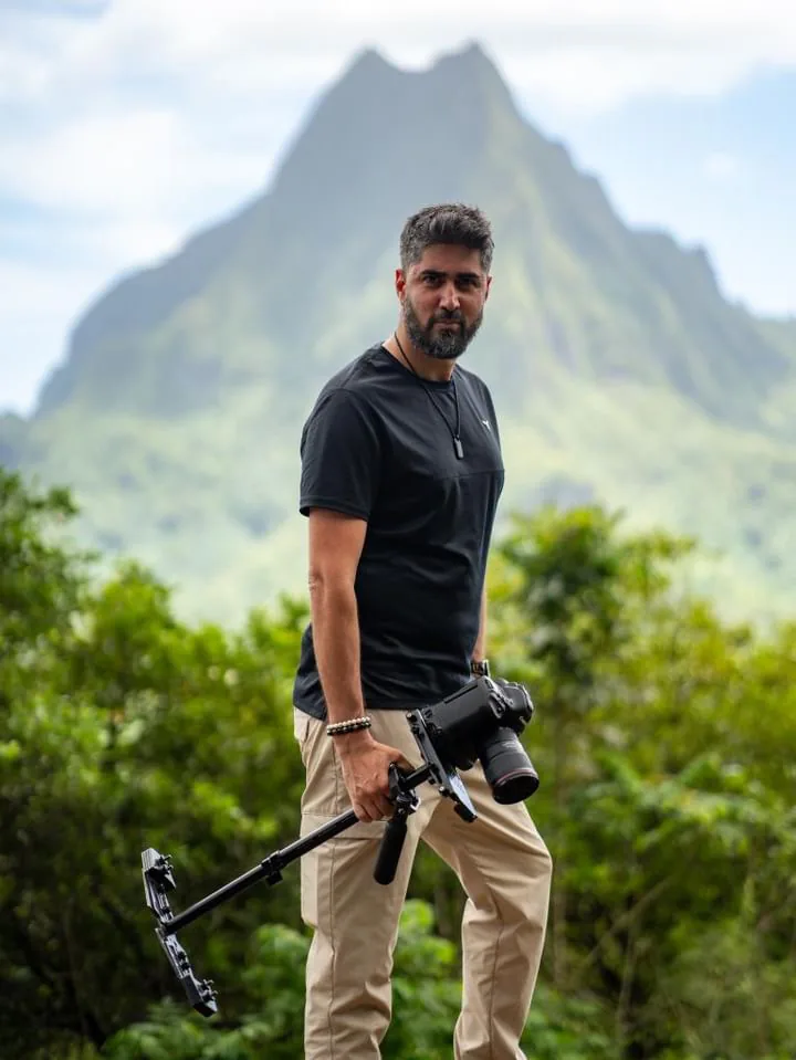 Filmmaker holding camera in mountains